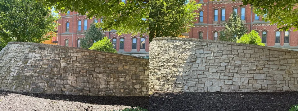 Before and after of a low curved stone wall cleaned at a commercial property in Cleveland, Ohio, by Patty's Pressure Washing