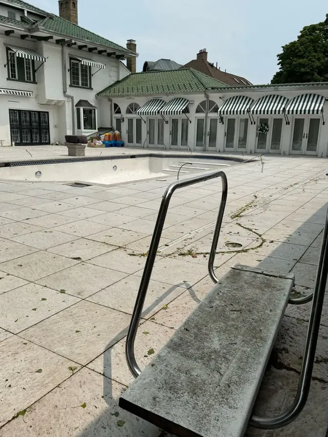 Travertine pool deck and diving board in Cleveland, Ohio, before cleaning