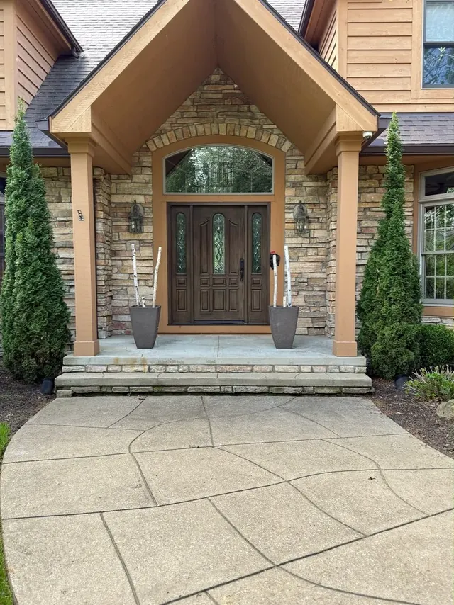 Stone front entry and exposed-aggregate walk in Bentleyville, Ohio, before cleaning